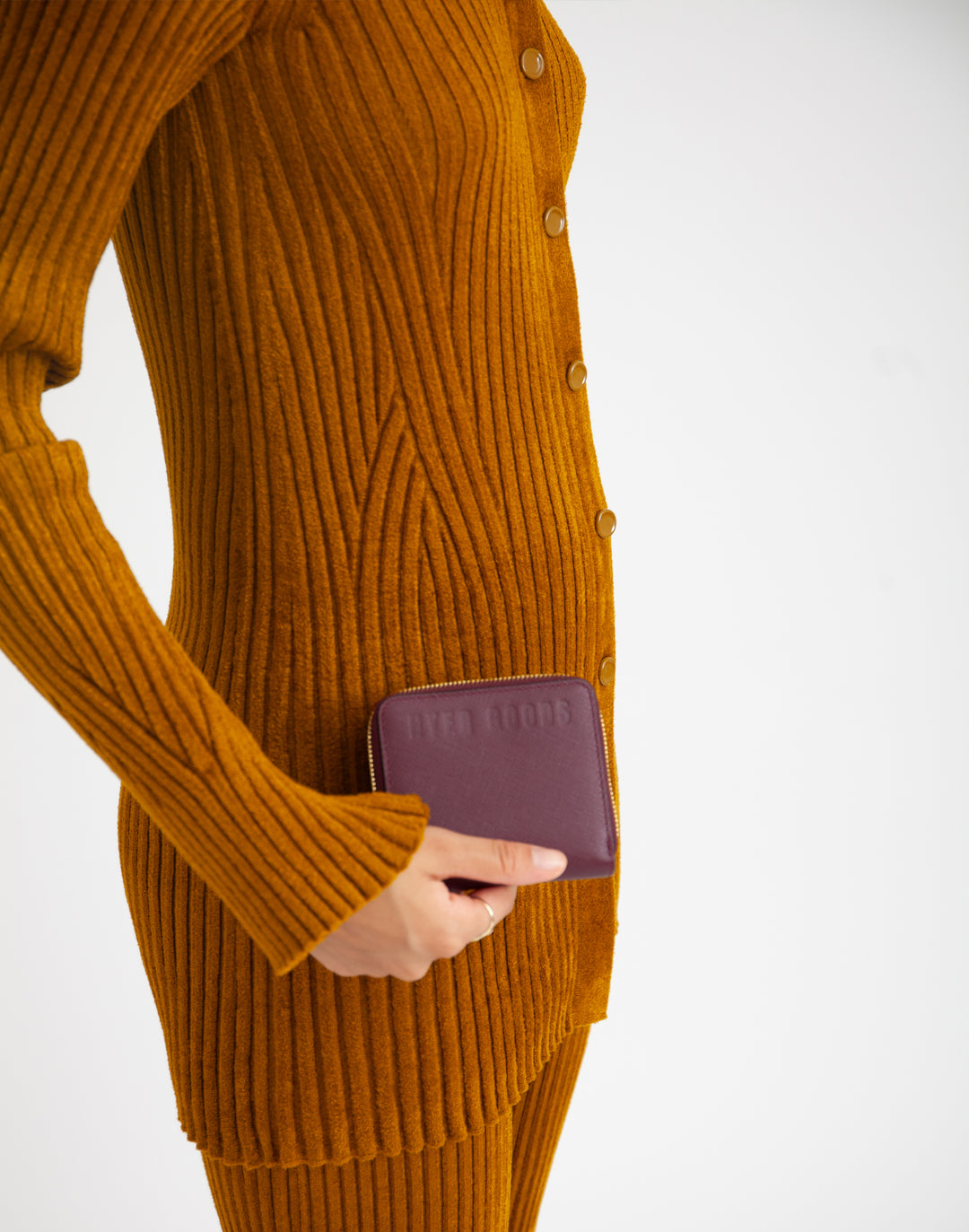 a woman holds a burgundy leather zip wallet #color_wine-saffiano