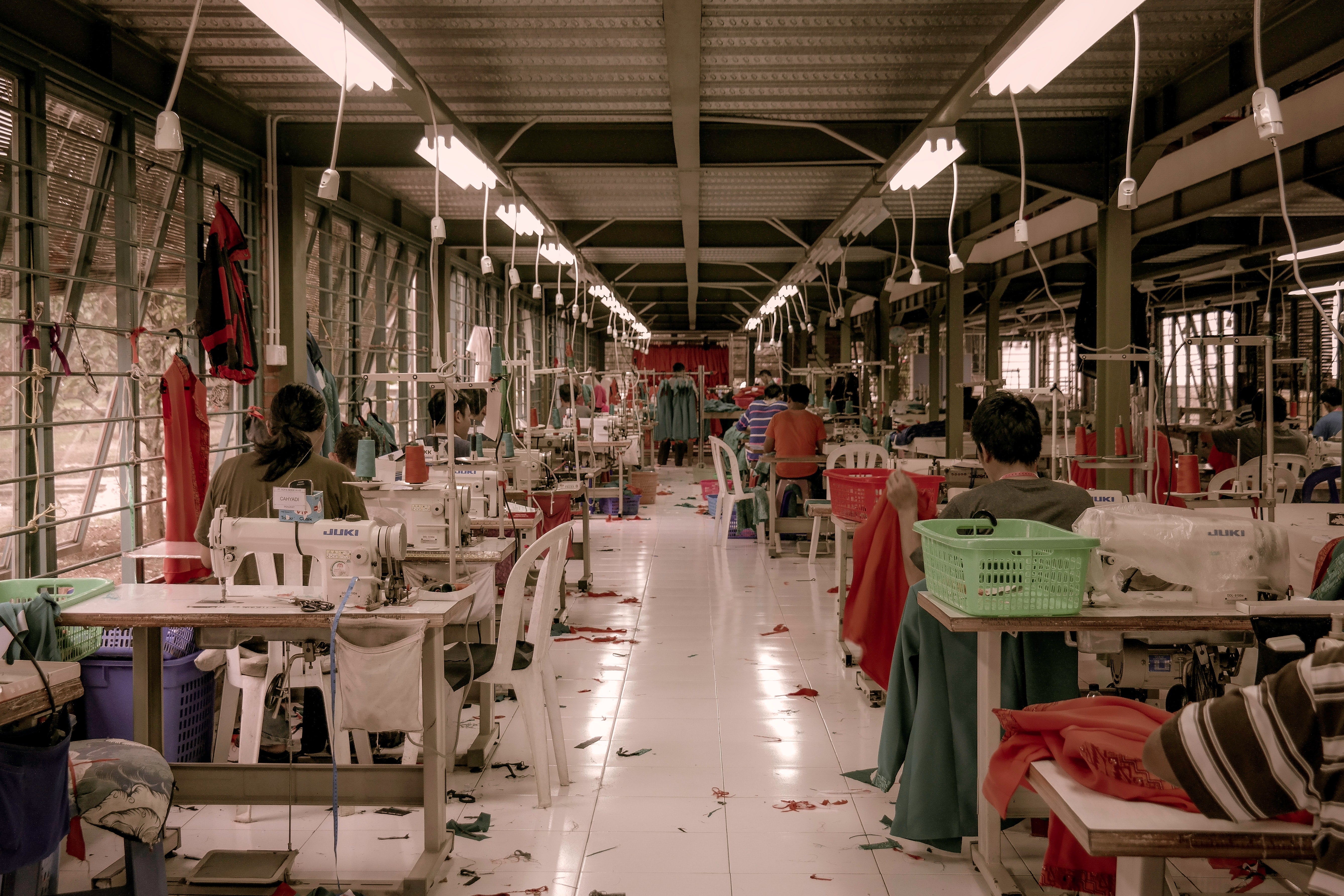 the interior of a garment manufacturing facility with rows of sewing machines