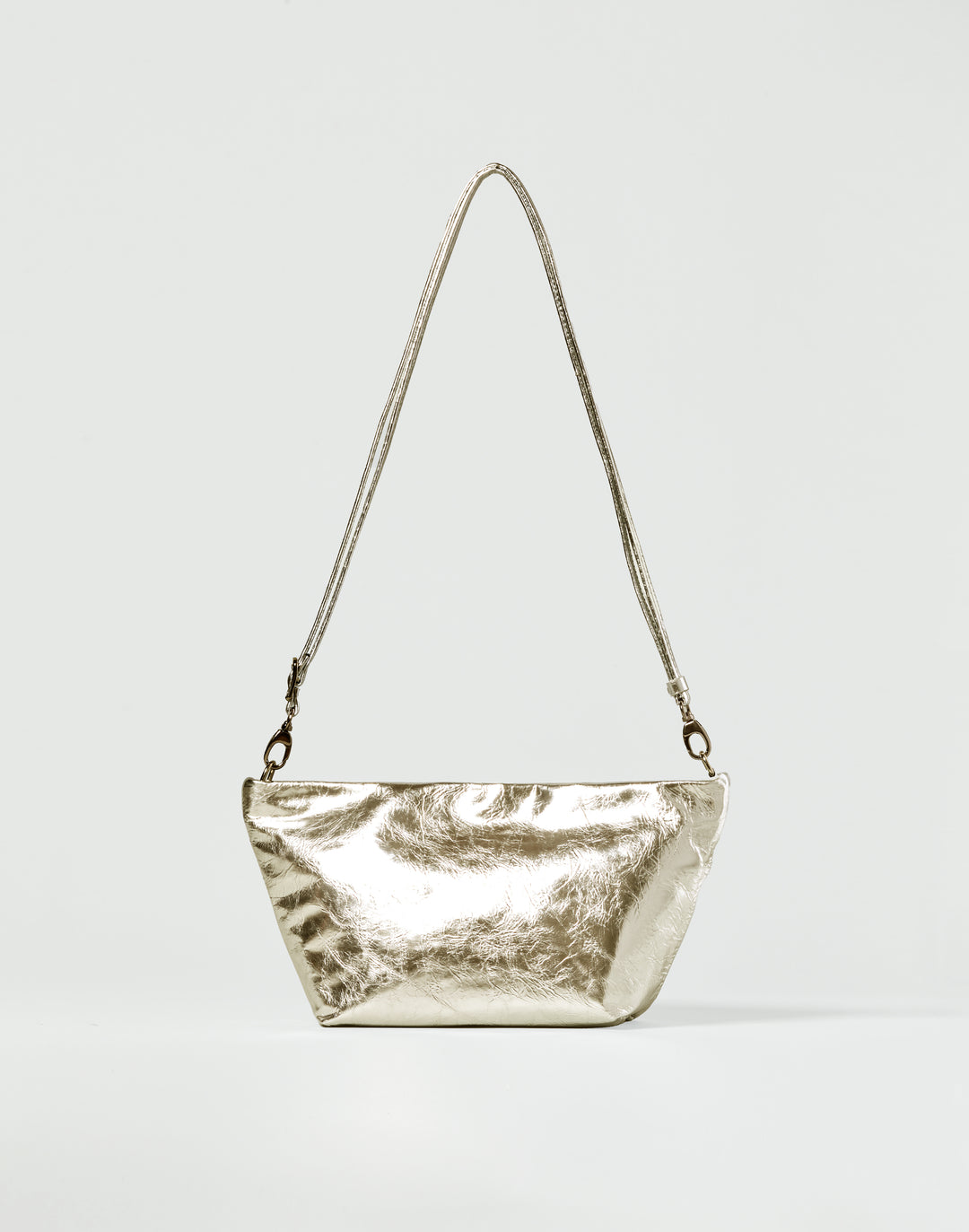 a gold leather shoulder bag with thin strap on a grey background #color_gold