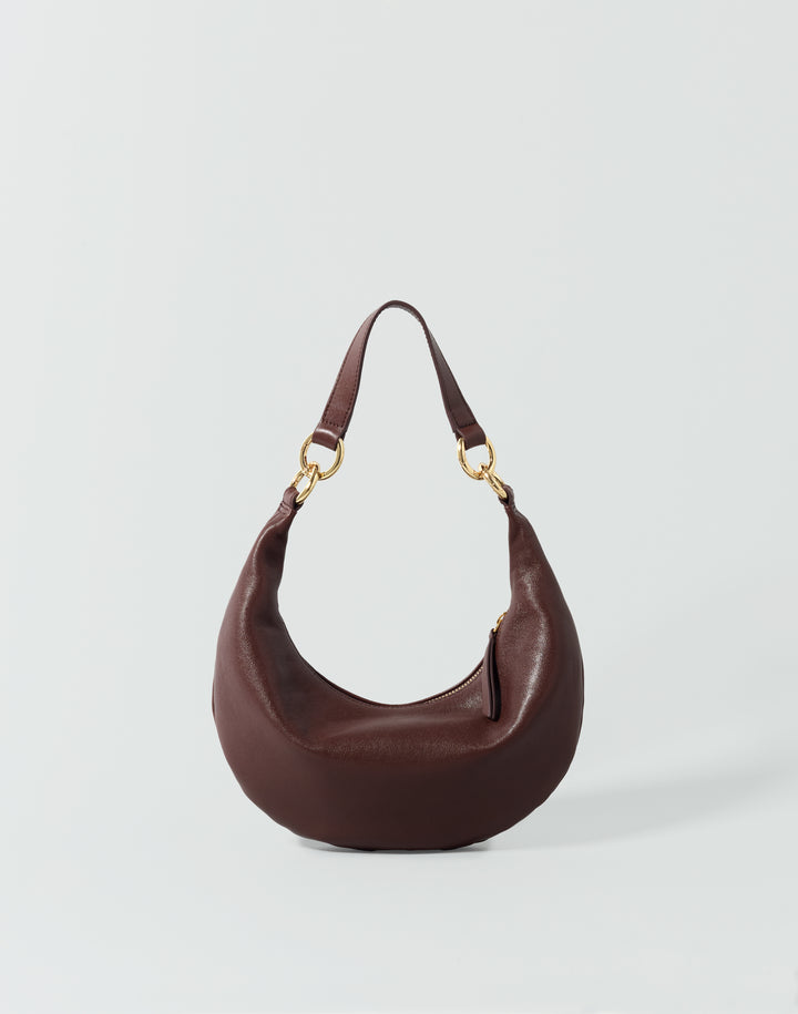 A reddish brown leather crescent-shaped shoulder bag with gold-tone hardware, displayed on a light gray background. #color_bordeaux-vintage