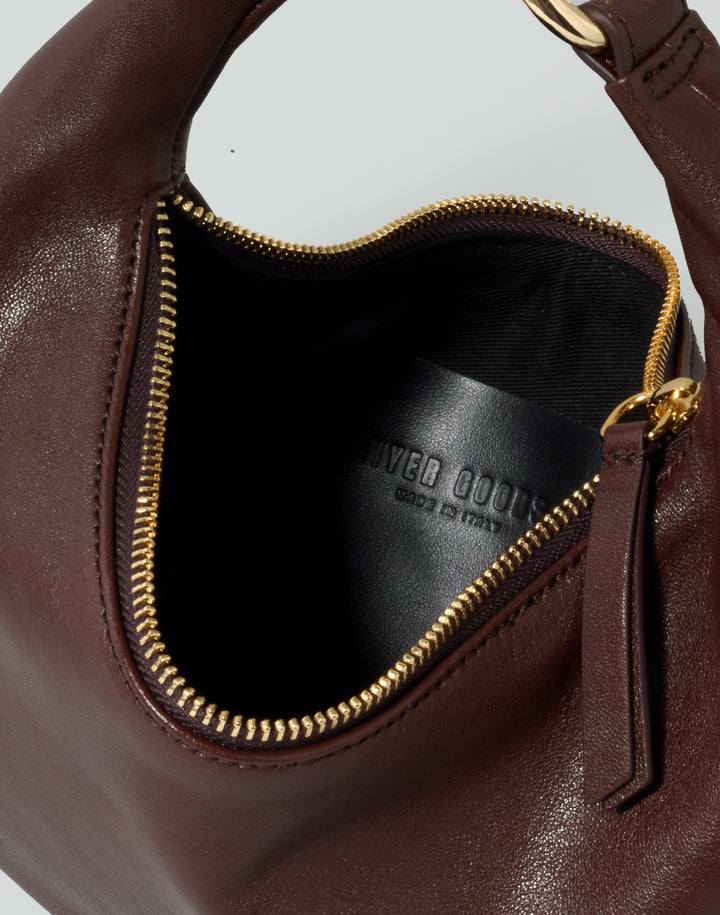 inside view of a leather patch pocket inside a reddish brown bag with a gold zipper #color_bordeaux-vintage