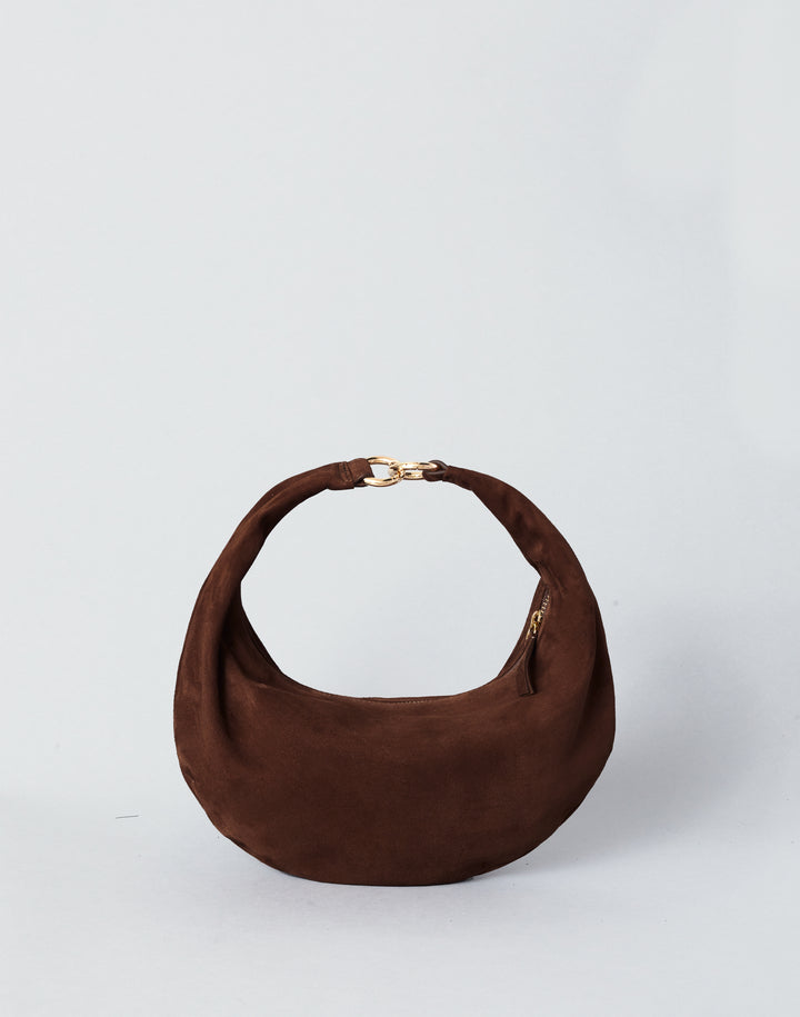 A HYER GOODS Piccola Ring Bag dark brown suede crescent-shaped shoulder bag with a gold-tone chain detail at the top of the strap, set against a plain light gray background. #color_chocolate-suede