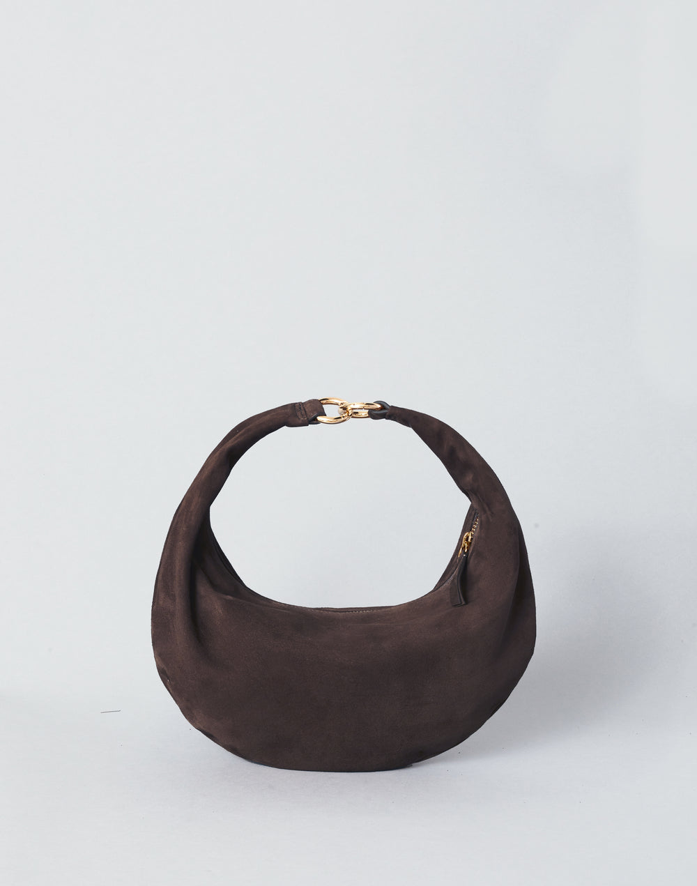 A HYER GOODS Piccola Ring Bag dark brown suede crescent-shaped shoulder bag with a gold-tone chain detail at the top of the strap, set against a plain light gray background. #color_chocolate-suede