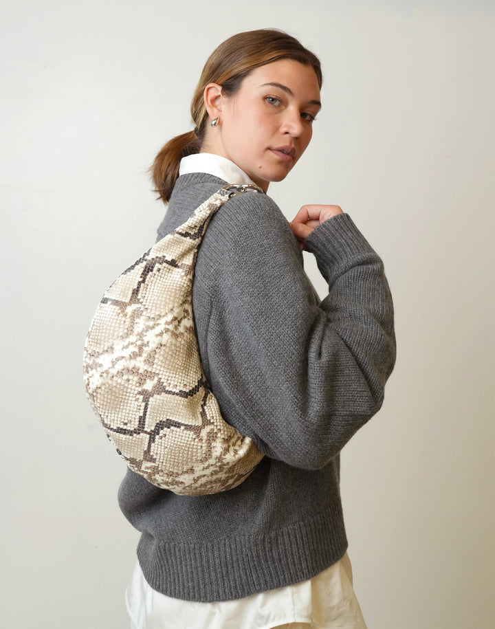 a woman in a grey sweater wears a HYER GOODS convertible python crossbody hobo crescent bag Piccola ring bag #color_python-no-2