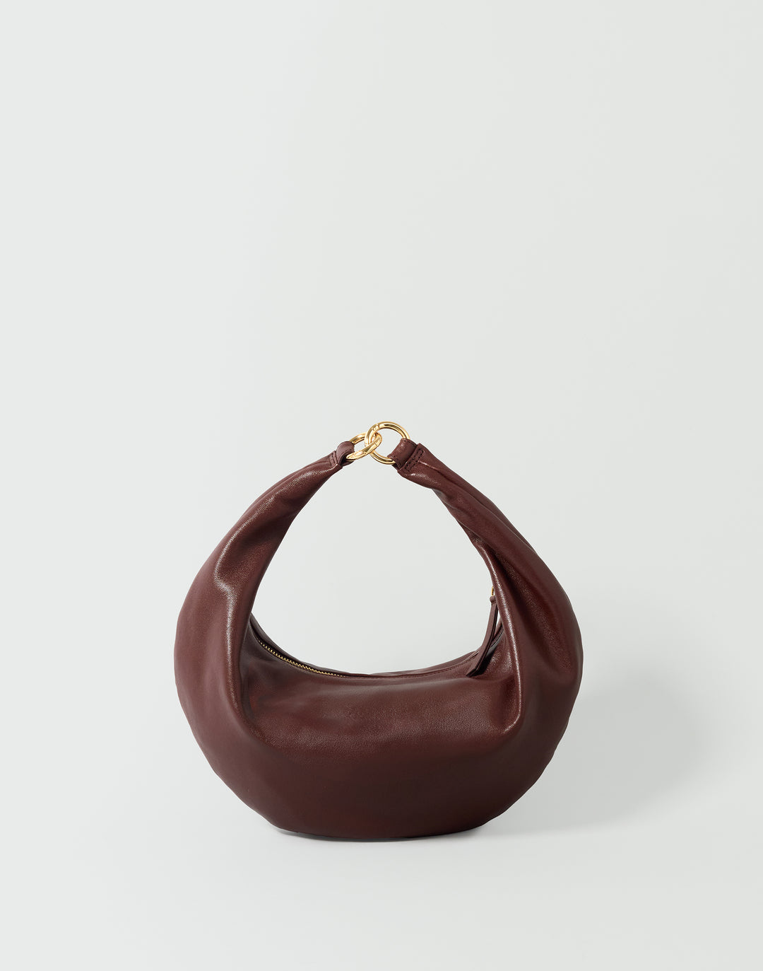 A dark brown leather crescent-shaped shoulder bag with a gold-tone ring detail at the top handle, set against a plain light gray background.#color_bordeaux-vintage