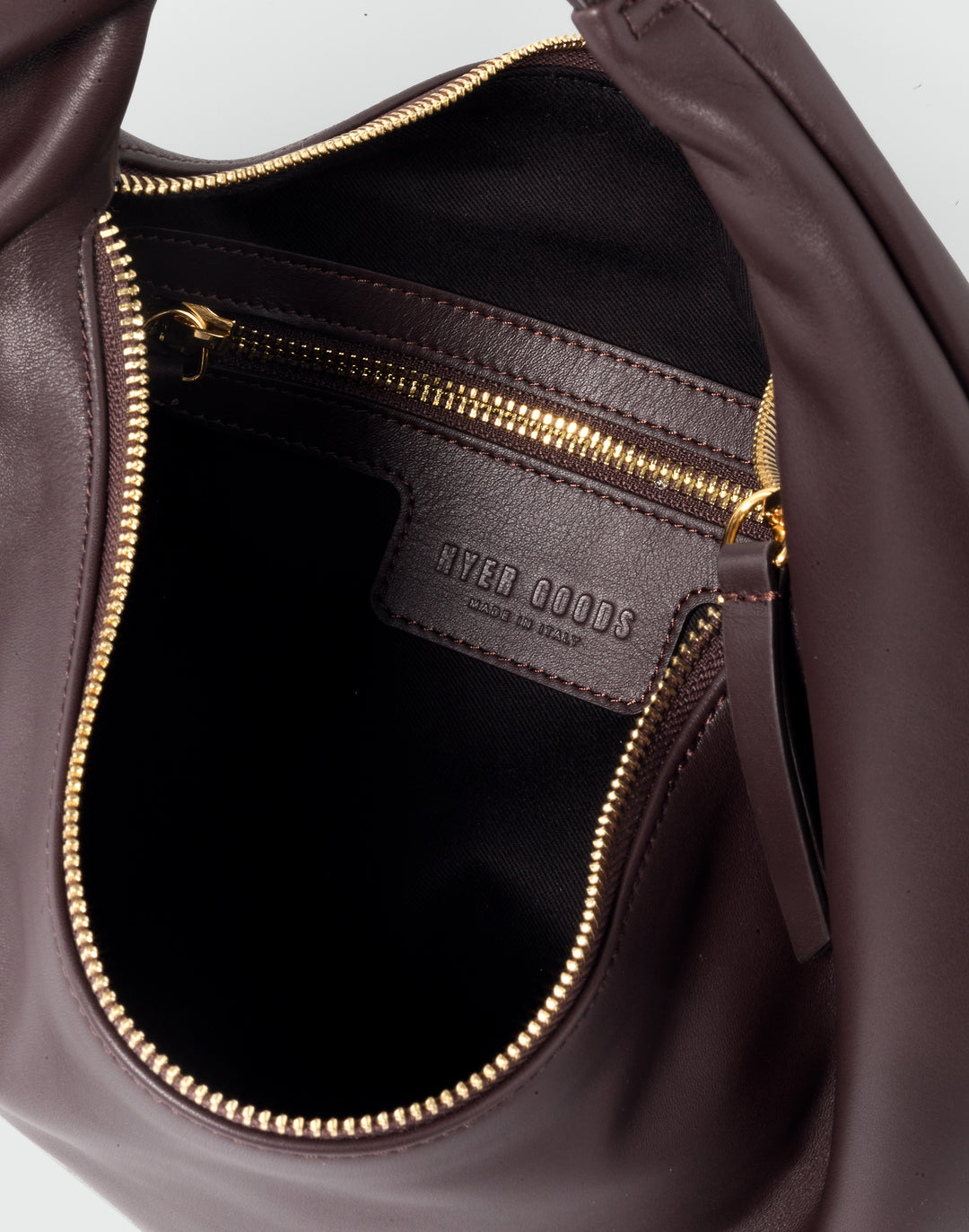 inside view of a brown leather bag with a gold zipper pocket inside and a HYER GOODS logo debossing #color_chocolate