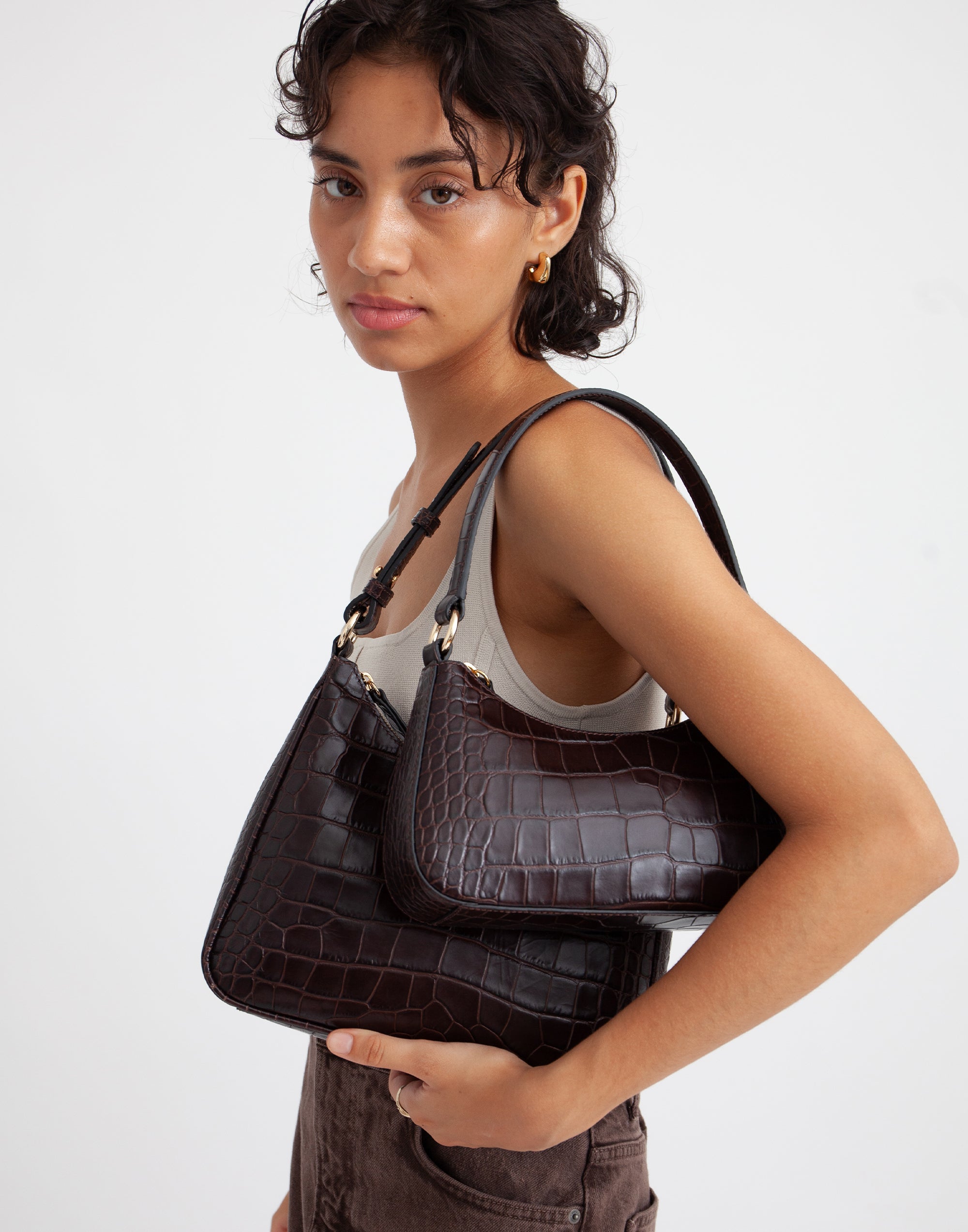 a woman carries 2 chocolate croc shoulder bags on her shoulder