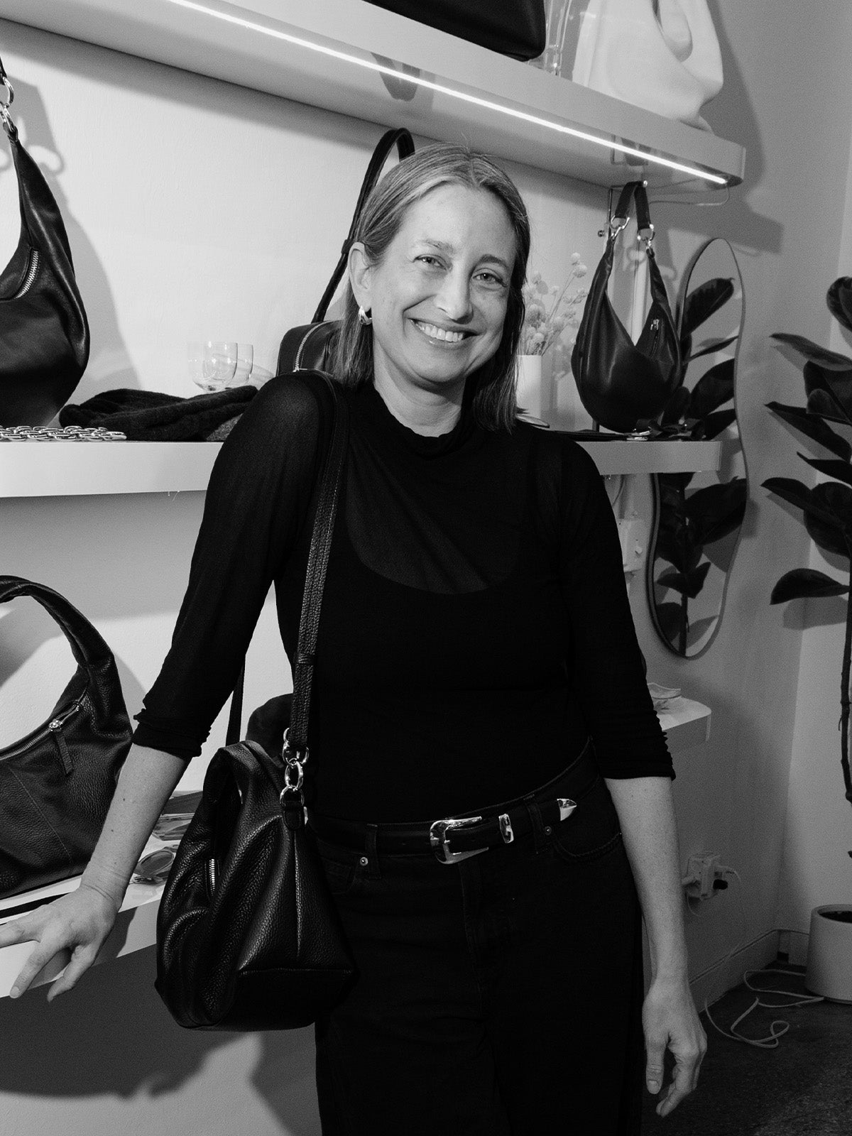 Dana Cohen, founder of HYER GOODS, holding a sustainable Italian leather handbag made from deadstock leather.