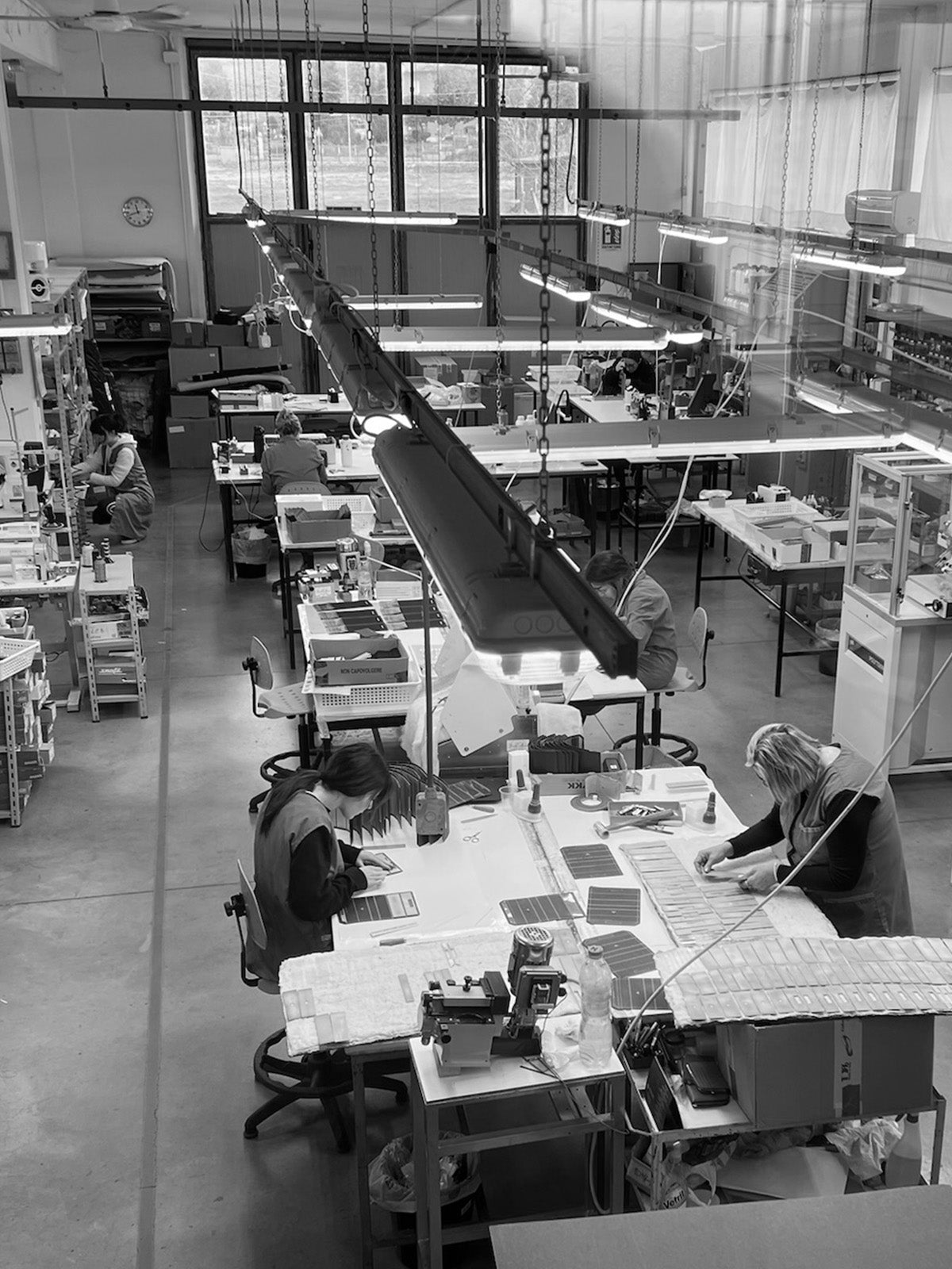 Artisans crafting Italian leather handbags in a family-owned factory in Italy.